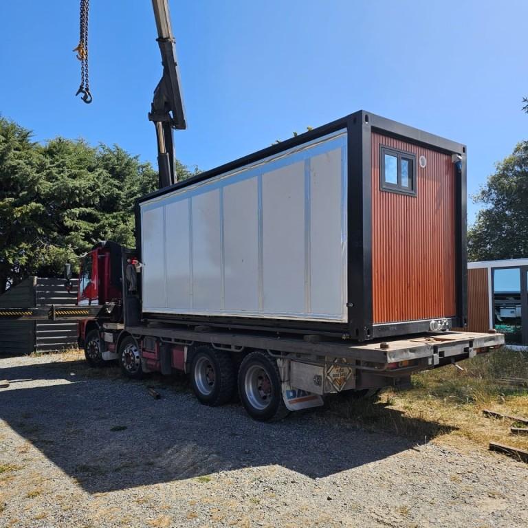 Transportable home being loaded onto a truck for delivery in New Zealand